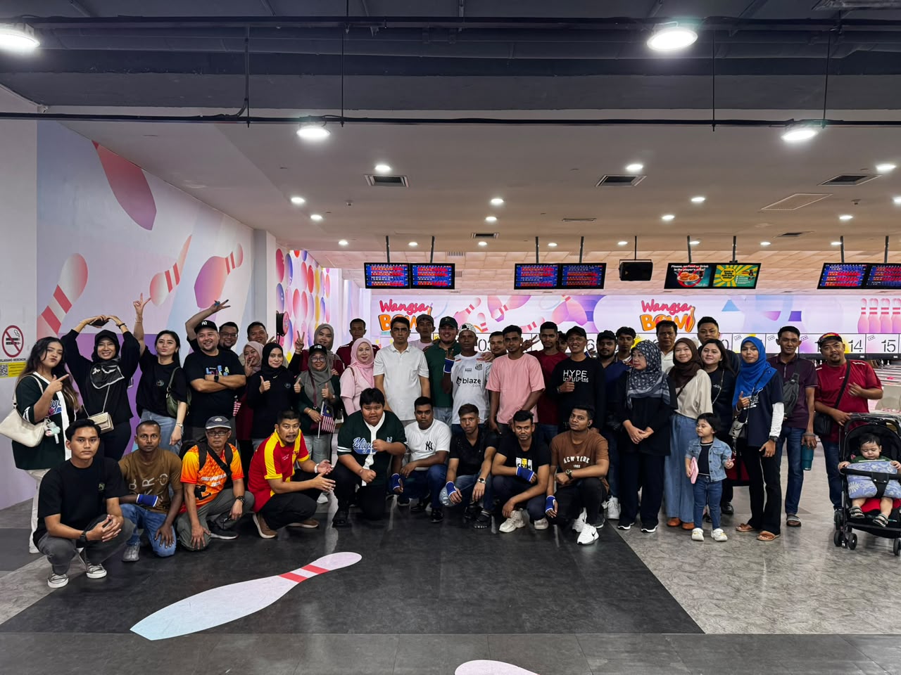 About fifty staff and family members, children among them, gathered in front of the bowling lanes.