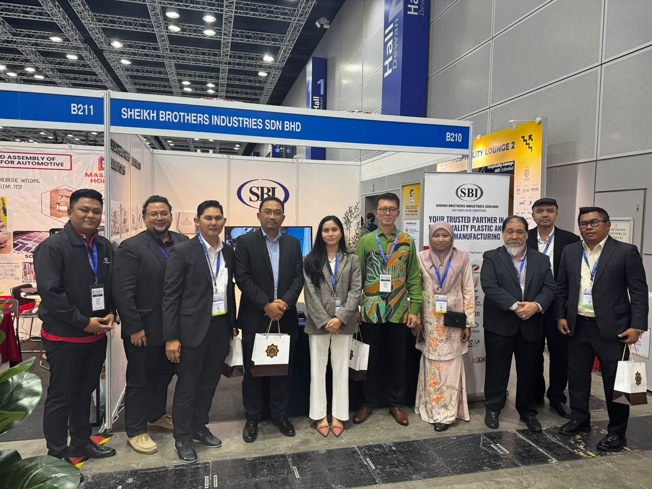Ten people standing in front of SBI's stand, under a fascia reading Sheikh Brothers Industries Sdn Bhd.