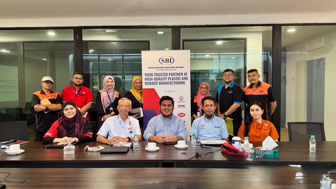 MARii's team and SBI staff seated and standing around a meeting table in SBI's meeting room, beside an SBI banner.