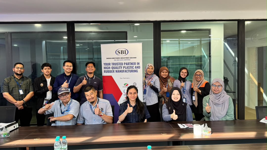 Proton's auditors and SBI staff giving a thumbs-up around a meeting table in SBI's meeting room, beside an SBI banner.