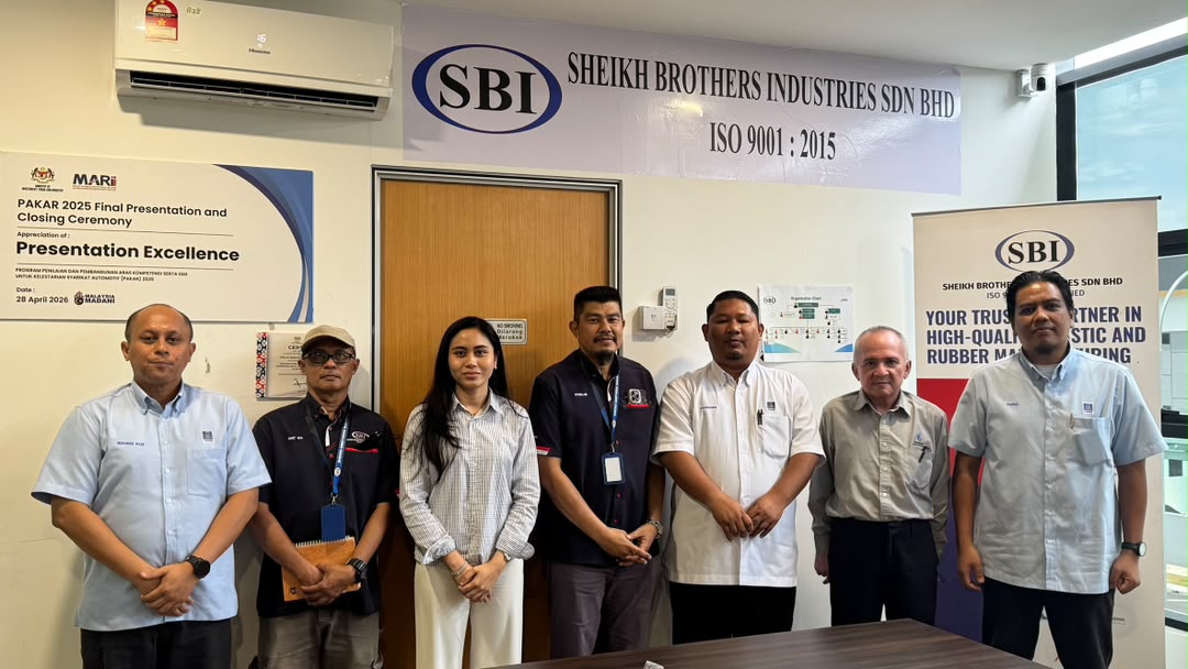 Seven people standing in SBI's meeting room beneath a banner reading Sheikh Brothers Industries Sdn Bhd, ISO 9001:2015, beside a PAKAR 2025 appreciation board.
