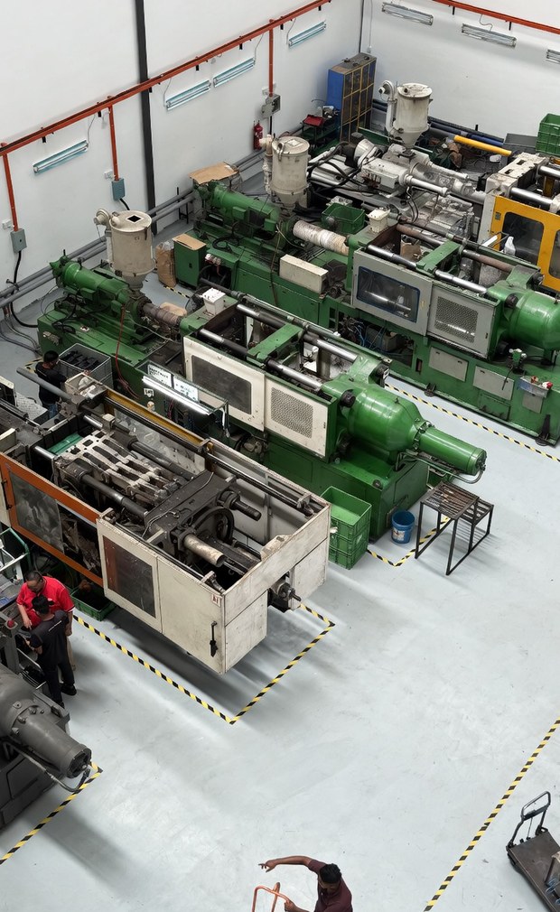 The molding hall from above: two rows of injection presses with yellow-marked walkways between them.
