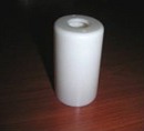 A white cylindrical outer cover with a hole through its top.